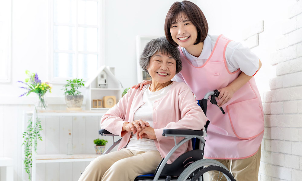 車いすを利用する方に寄り添う介護スタッフ